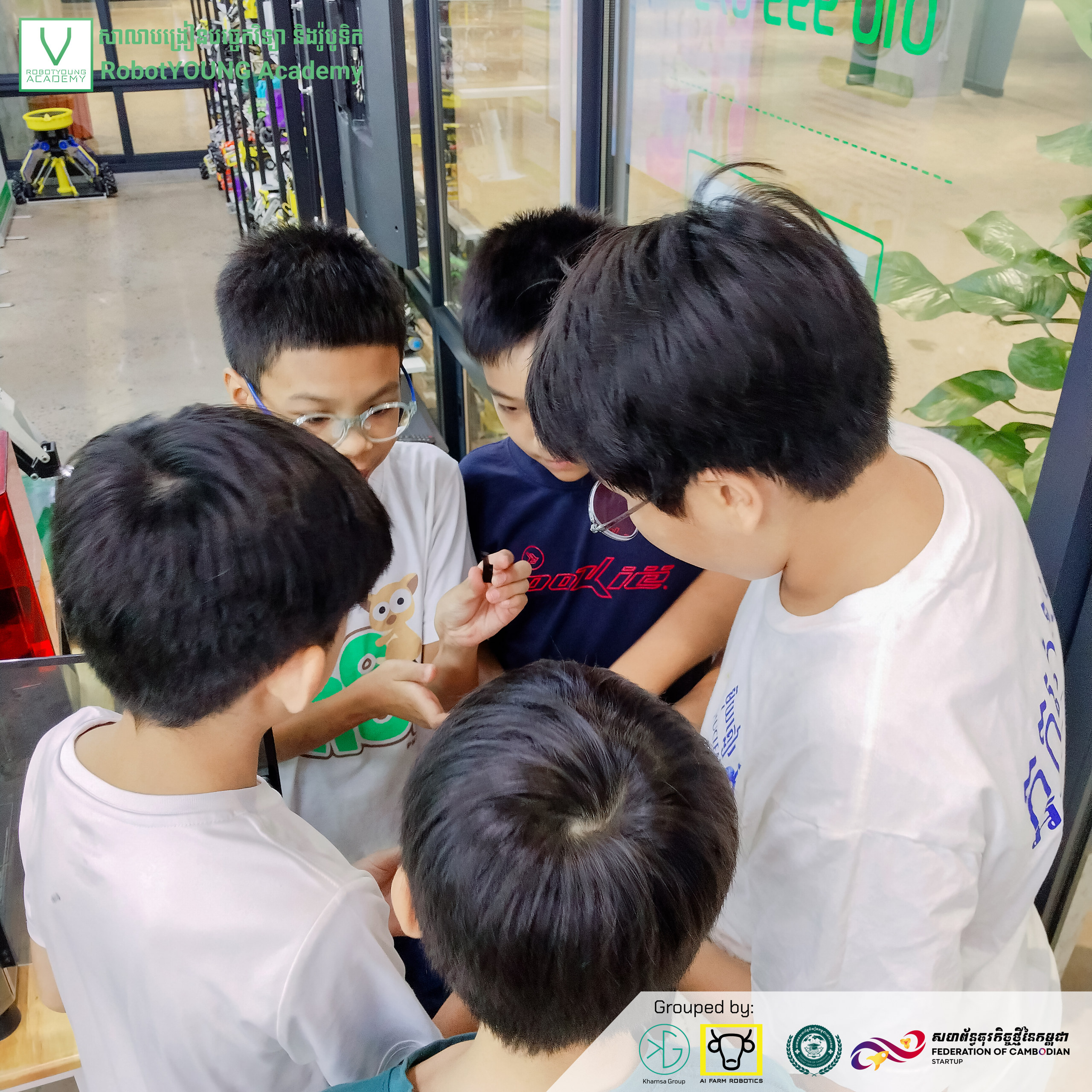 Children gathered around a small green object during a group activity