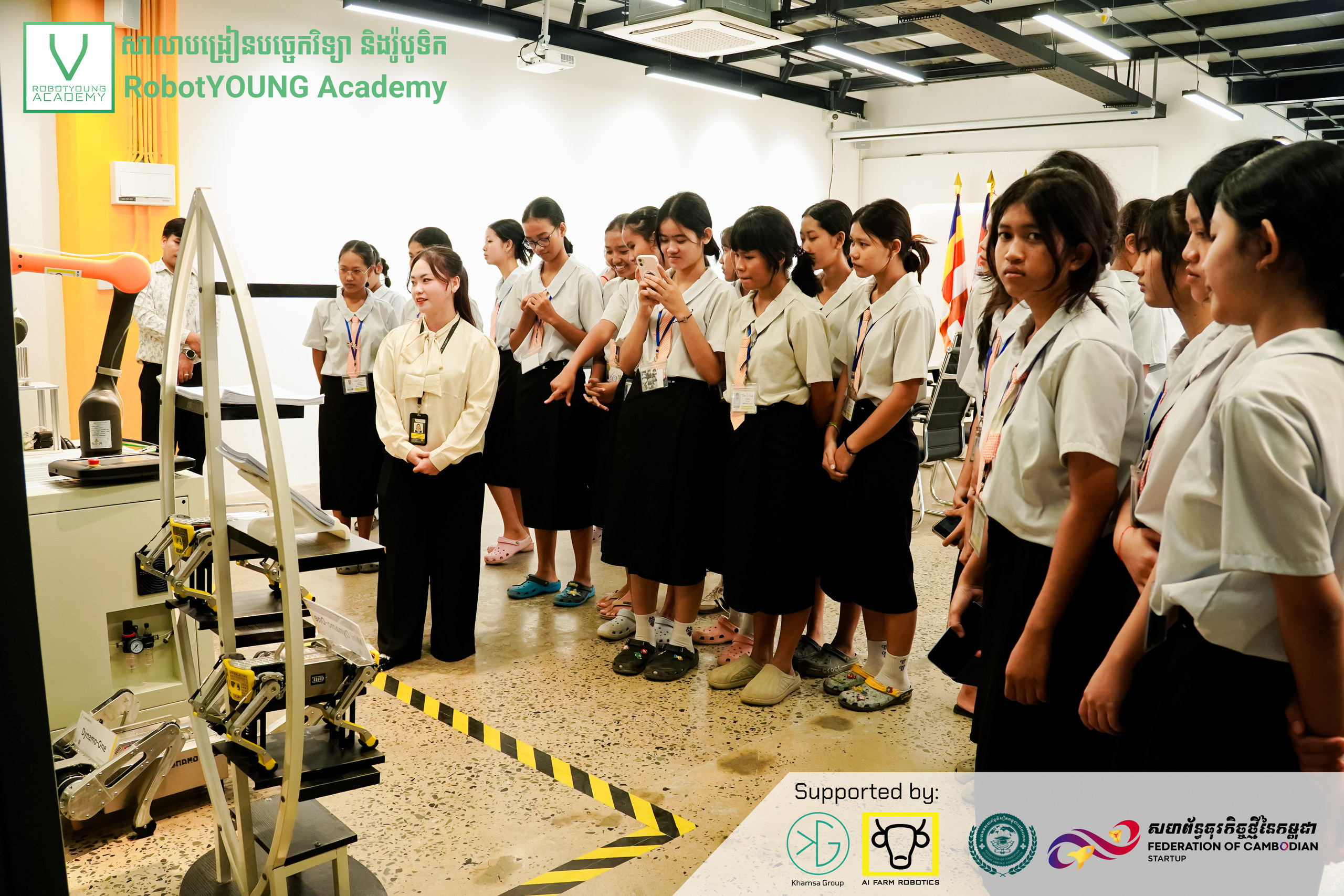 Students standing around industrial equipment during a guided workshop visit
