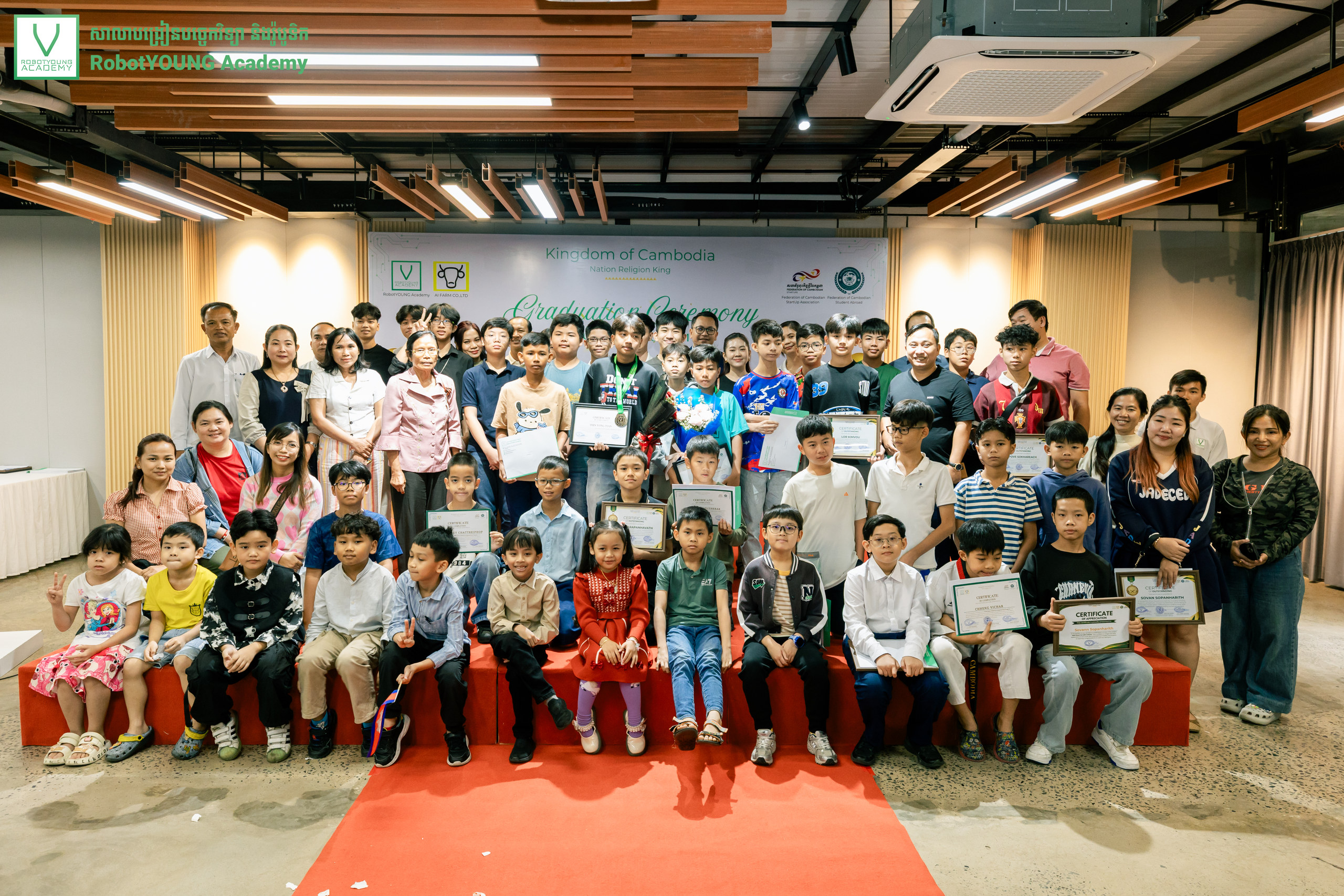 Students and adults celebrating graduation with certificates and medals
