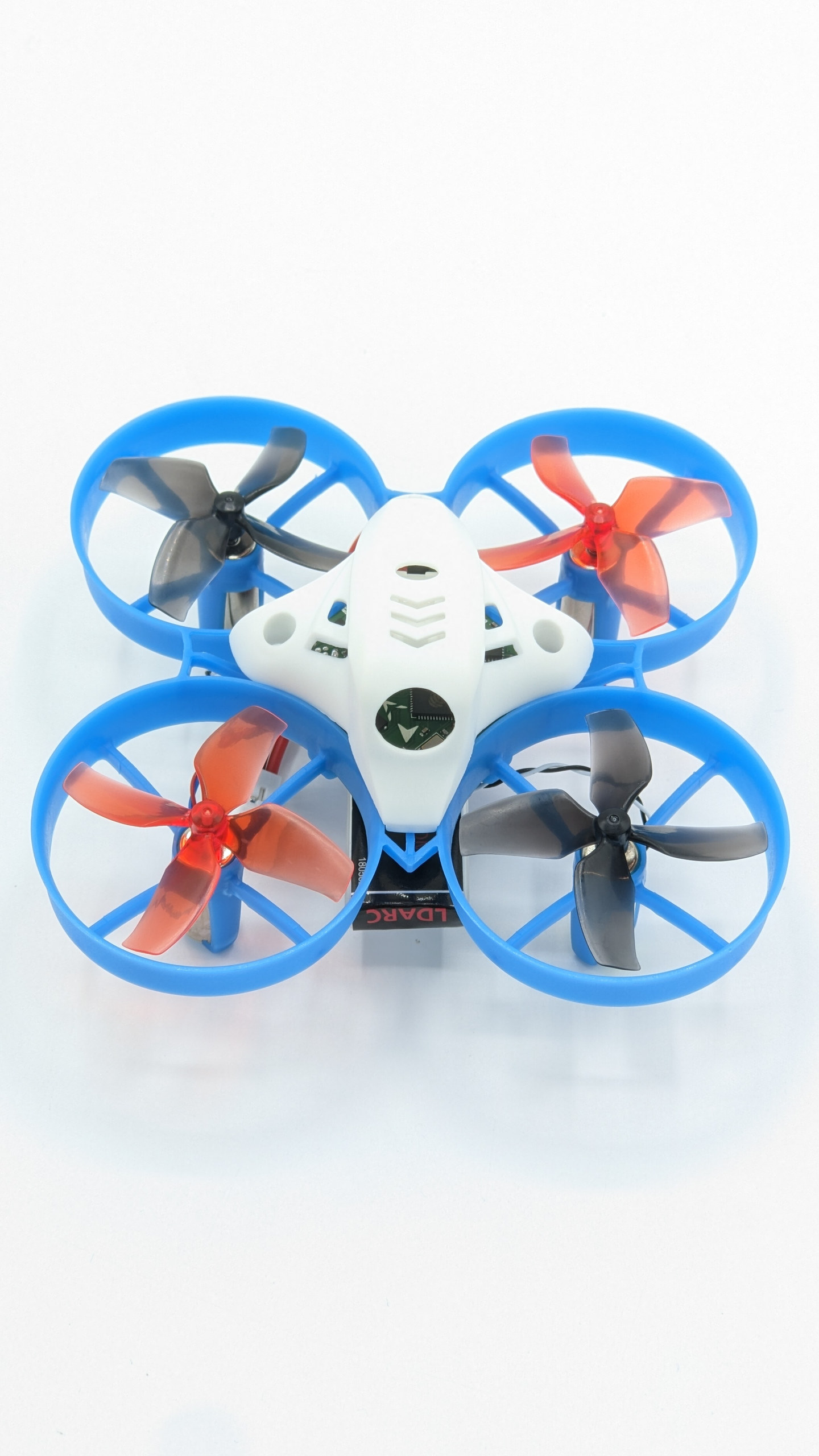 A small white quadcopter with blue propeller guards and blue and orange propellers